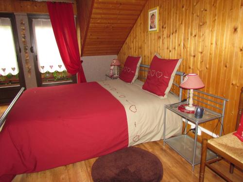 a bedroom with a large bed with red pillows at Das Gîte Fleuri Mit Einer Herrlichen Aussicht in Hazelbourg