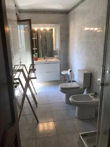 ブラガにあるCasa Monsenhorのバスルーム(トイレ2つ、シンク、シャワー付)