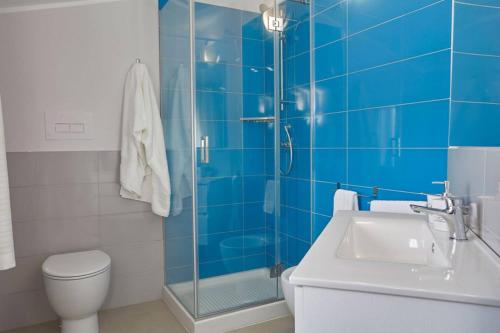 a blue tiled bathroom with a toilet and a sink at Villa Biancolilla in Castellammare del Golfo