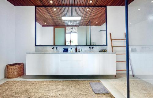 La salle de bains est pourvue de placards blancs et d'un grand miroir. dans l'établissement Amazing 3BDR-Villa Canggu/Seseh 2min walk to Beach, à Canggu