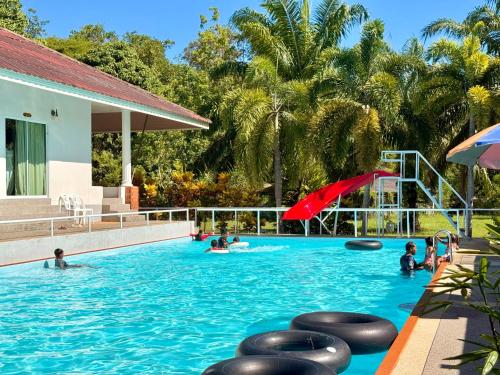 a swimming pool with people in the water at Avare House Krabi in Ao Nam Mao