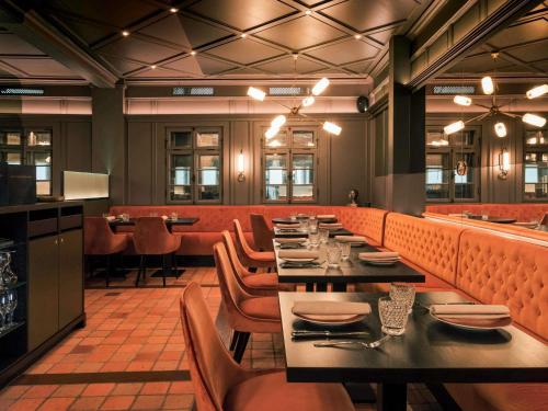 Un comedor con mesas y sillas en un restaurante. en Sofitel Luxembourg Europe, en Luxemburgo