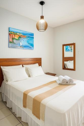 a bedroom with a large bed with white sheets at Pousada o pescador in Icapuí