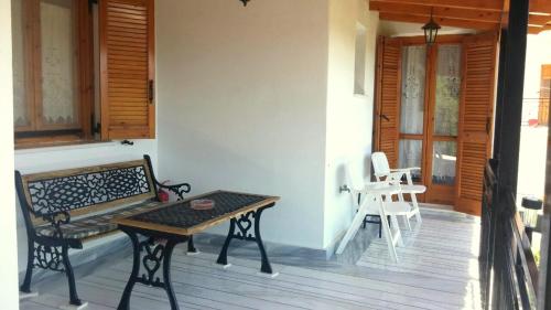 a patio with a bench and a table on a porch at Dafni Apartments in Kastri