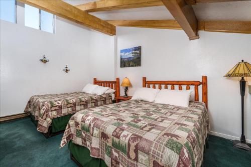 2 letti in una camera con pareti bianche e soffitti in legno di (A204) Loft Condominiums a Yosemite West