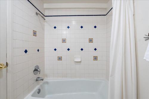 e bagno con vasca bianca e tenda doccia. di (A204) Loft Condominiums a Yosemite West