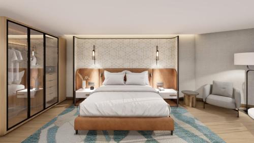 a bedroom with a large bed and a chair at voco CAIRO ARABELLA PLAZA by IHG in Cairo