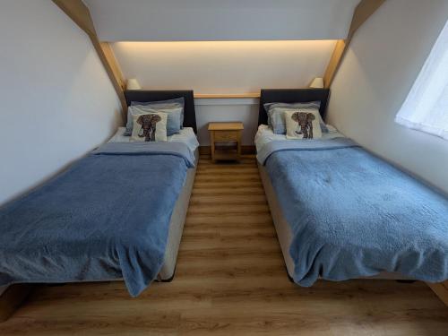Dos camas en una habitación pequeña con en Cointree, en Sturminster Newton
