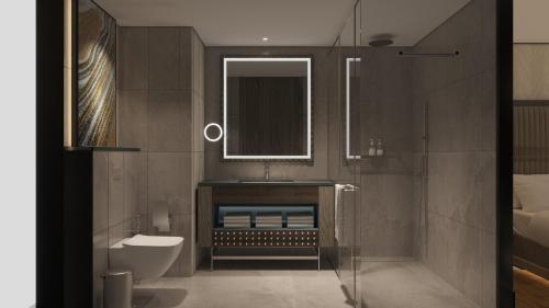 ein Badezimmer mit Waschbecken, Toilette und Spiegel in der Unterkunft Crowne Plaza Riyadh - Al Takhassusi by IHG in Riad