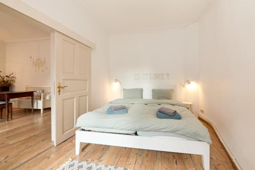a white bedroom with a white bed with blue pillows at Altstadt Residenz in Bernkastel-Kues