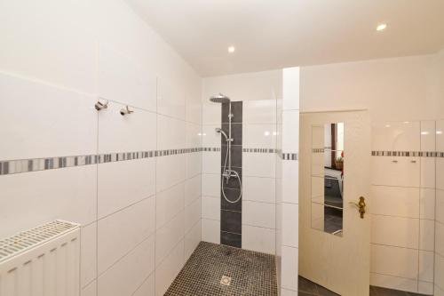 a white bathroom with a shower with a glass door at Altstadt Residenz in Bernkastel-Kues