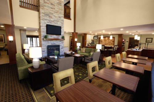 a restaurant with tables and chairs and a fireplace at Staybridge Suites Irving Las Colinas by IHG in Irving