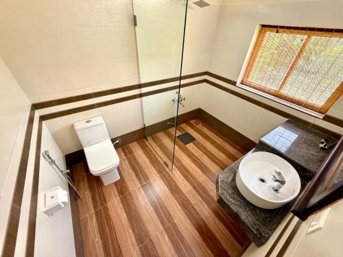 KappilにあるMaadathil Cottages & Beach Resortのトイレ、洗面台、シャワー付きのバスルーム