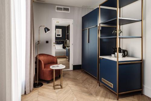 a room with a blue partition with a chair and a table at The Cumberland by NEU Collective in Valletta