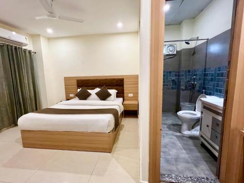 a bedroom with a bed and a bathroom with a toilet at The Aqua Lodge, A budget friendly hotel - Haridwar in Haridwār