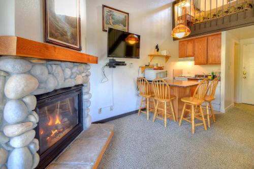 un salon avec une cheminée et une table avec des chaises dans l'établissement (A212) Loft Condominiums, à Yosemite West