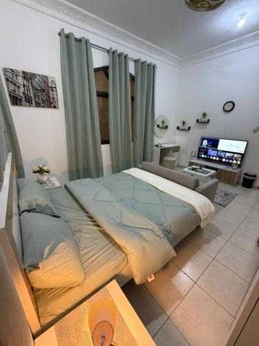 a bedroom with a large bed and a television at استديو الخالديه in Abu Dhabi
