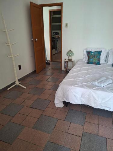 ein Schlafzimmer mit einem Bett und einem gefliesten Boden in der Unterkunft Oasis do Leme in Rio de Janeiro