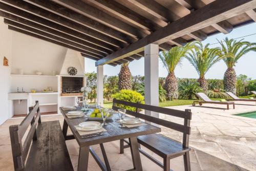 an outdoor dining room with a table and chairs at Los Olivos - Casa rural en exclusiva finca privada in Sant Lluis