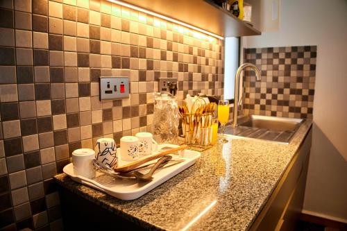 a kitchen counter with cups and utensils on a tray at Juwell Haven in Nairobi
