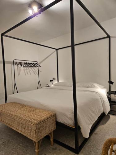 a bedroom with a black canopy bed with a ottoman at La Cereria in Chiavenna