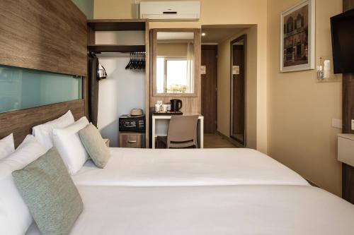 Postel nebo postele na pokoji v ubytování 115 The Strand Hotel by NEU Collective