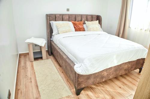a bedroom with a large bed with a wooden headboard at Juwell Haven in Nairobi