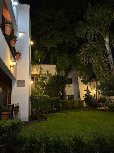 a house with a green yard at night at Quinta María Hotel Boutique & Spa in Querétaro