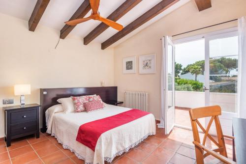 a bedroom with a bed and a large window at Los Olivos - Casa rural en exclusiva finca privada in Sant Lluis