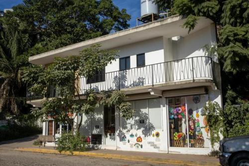a white building with a balcony on top of it at Vista Sayulita in Sayulita
