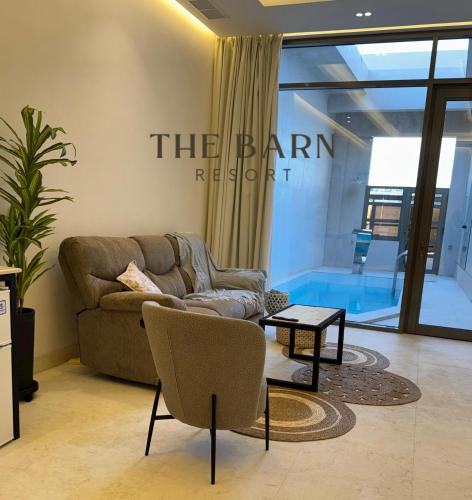 ein Wohnzimmer mit Sofa und Tisch in der Unterkunft The Barn Resort Sea View منتجع ذا بارن in An Nāmī