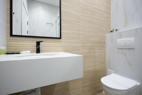 a bathroom with a white sink and a toilet at Or Haganuz in Dobrovelychkivka