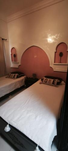 Un dormitorio con dos camas y un arco encima de ellas. en Riad Naim, en Marrakech