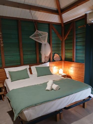 a bedroom with a large bed with towels on it at Villa Ti Colibri in Bouillante
