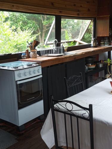 a kitchen with a stove and a counter with a table at Morocha in Estación Costa Azul