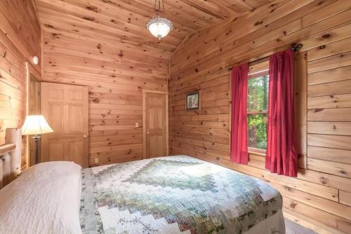 ein Schlafzimmer mit einem Bett in einer Blockhütte in der Unterkunft Secluded Log Cabin with a Hot Tub near Bridle Trails in Logan, Ohio in Cedar Grove