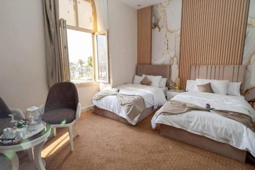 a bedroom with two beds and a chair and a table at lotus view El tahrir in Cairo