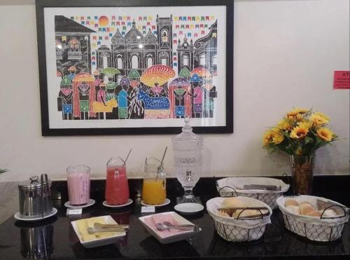 サンルイスにあるBoulevard Park Hotelの食べ物と飲み物が置かれたテーブルと壁に掛けられた絵