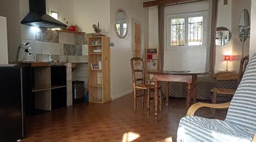 een keuken en woonkamer met een tafel en stoelen bij Studio privé - maison de village in Valensole