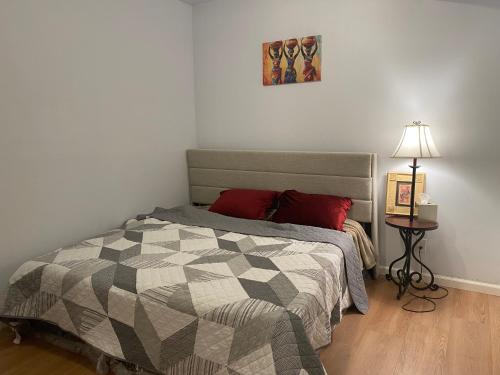 a bedroom with a bed and a table with a lamp at Suite in Lakeside house in Alpharetta