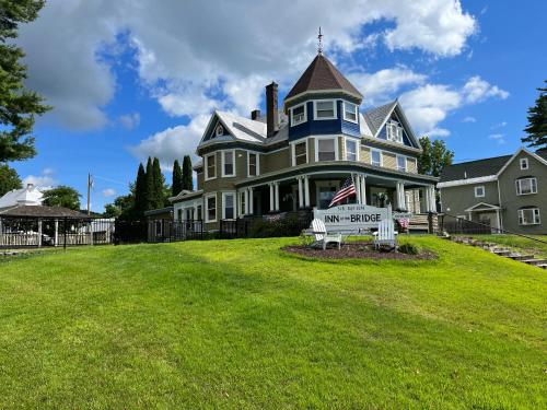 a large house with a sign in front of it at The Inn At The Bridge in Northville