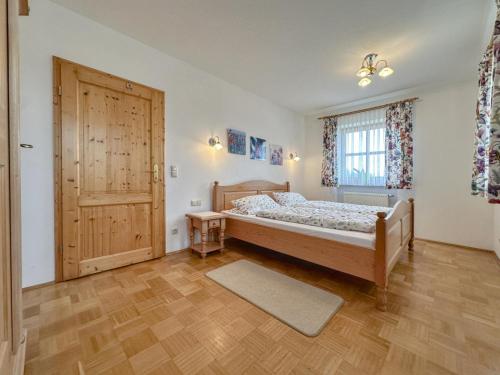 a bedroom with a bed and a wooden door at Blumenhof II in Dietersdorf