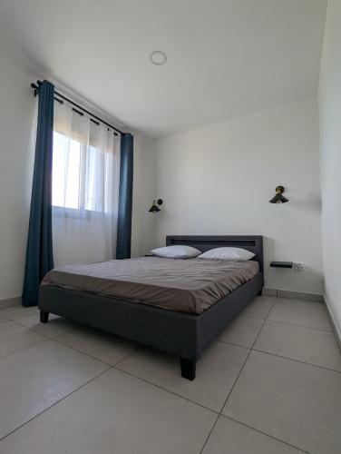 a bedroom with a large bed with a window at Le jamerosas in Le Tampon