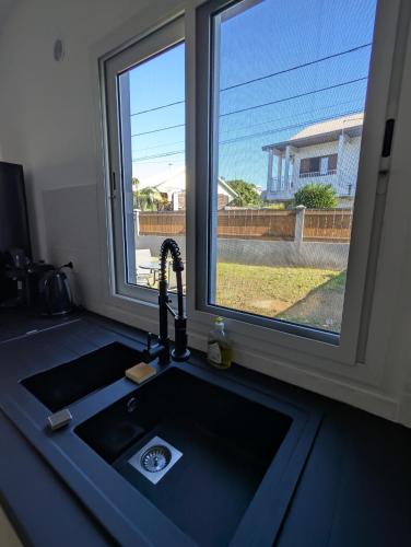 a kitchen sink with a window above it at Le jamerosas in Le Tampon