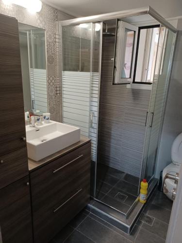 ein Badezimmer mit Waschbecken und Dusche in der Unterkunft Sea and City Voula Suite by First Class Properties in Athen