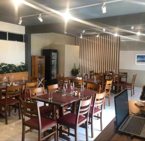 a dining room with tables and chairs and a laptop at Boulevard Park Hotel in São Luís