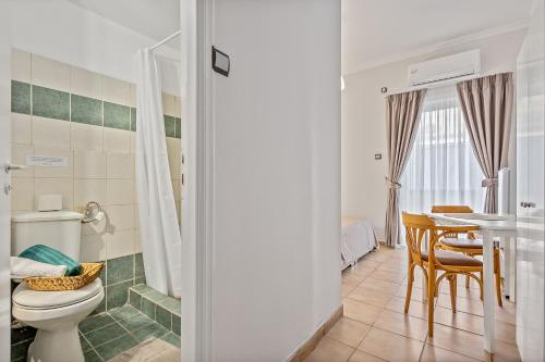 a bathroom with a toilet and a table with chairs at SALV3R Hotel in Athens