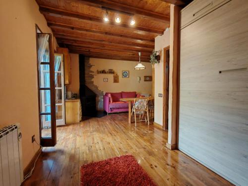 ein Wohnzimmer mit einem Tisch und einer rosa Couch in der Unterkunft Chimenea y encanto rústico, tu escapada - Cosmos 3 in Pla de l'Ermita