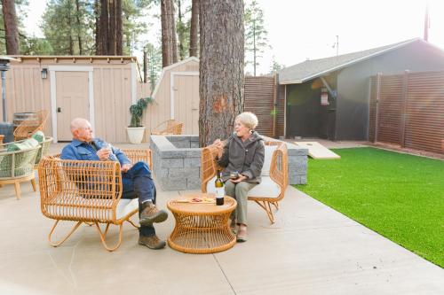 two older people sitting on chairs in a yard at Woody Mountain Bed & Breakfast in Flagstaff