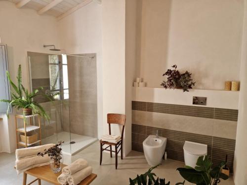 a bathroom with a shower and a toilet and a chair at Casa S'Urtzula in Sini